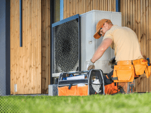 HVAC technician inspecting an outdoor unit at a home in East Tennessee, ensuring proper system functioning and efficiency during a home inspection.
