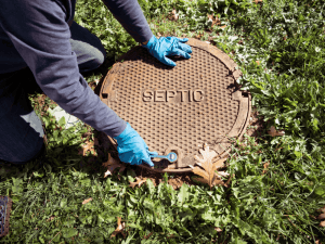 Inspector opening a septic tank lid during a property inspection in Gatlinburg, TN